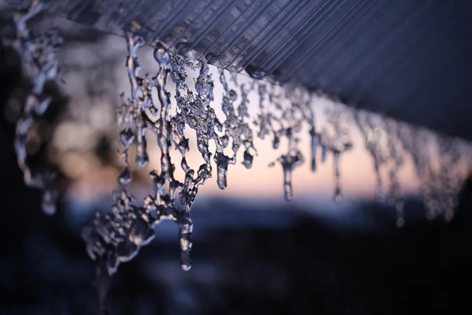 Icicles hanging along the underside of a roof edge