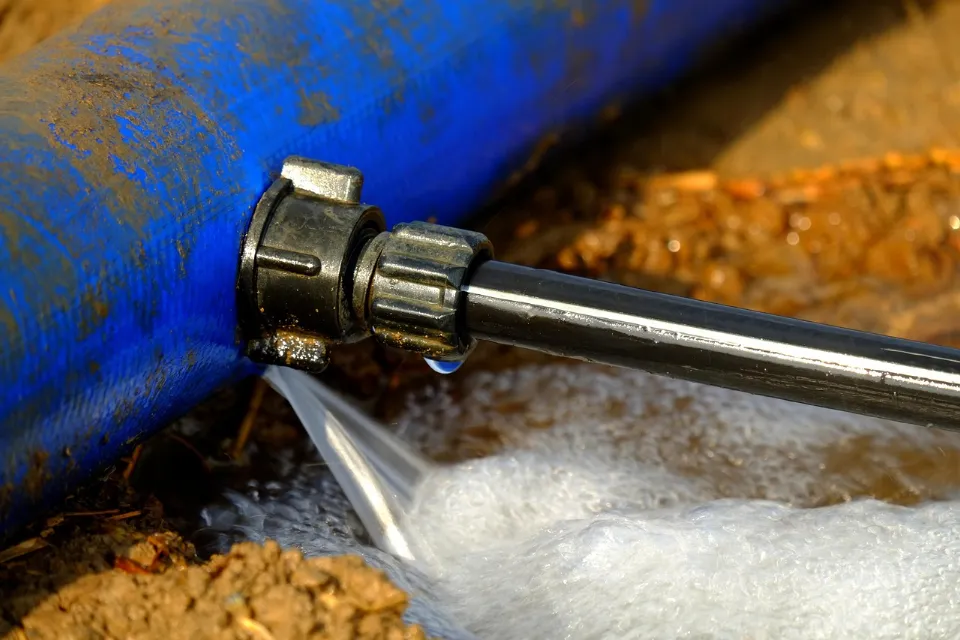 Water spraying from a leaking pipe connection onto the ground